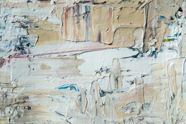 Close-up of textured abstract painting with layered acrylic paint in neutral tones.